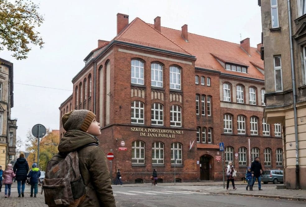 Uczeń z plecakiem stoi przed ceglanym budynkiem polskiej szkoły — moment wyboru właściwej placówki