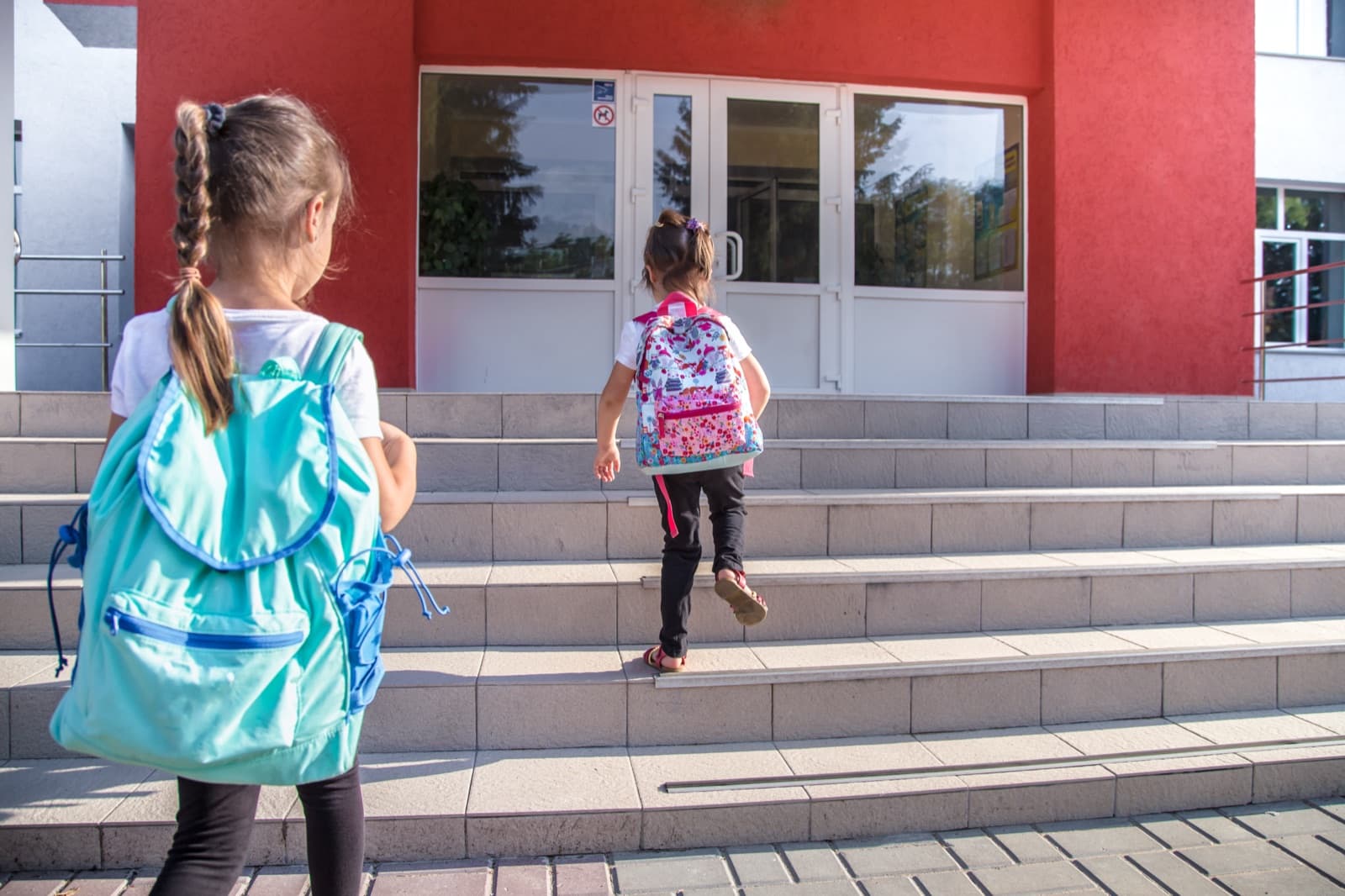 Dwie sale — z lewej sala Montessori z materiałami na półkach, z prawej sala waldorfska z akwarelami na ścianach