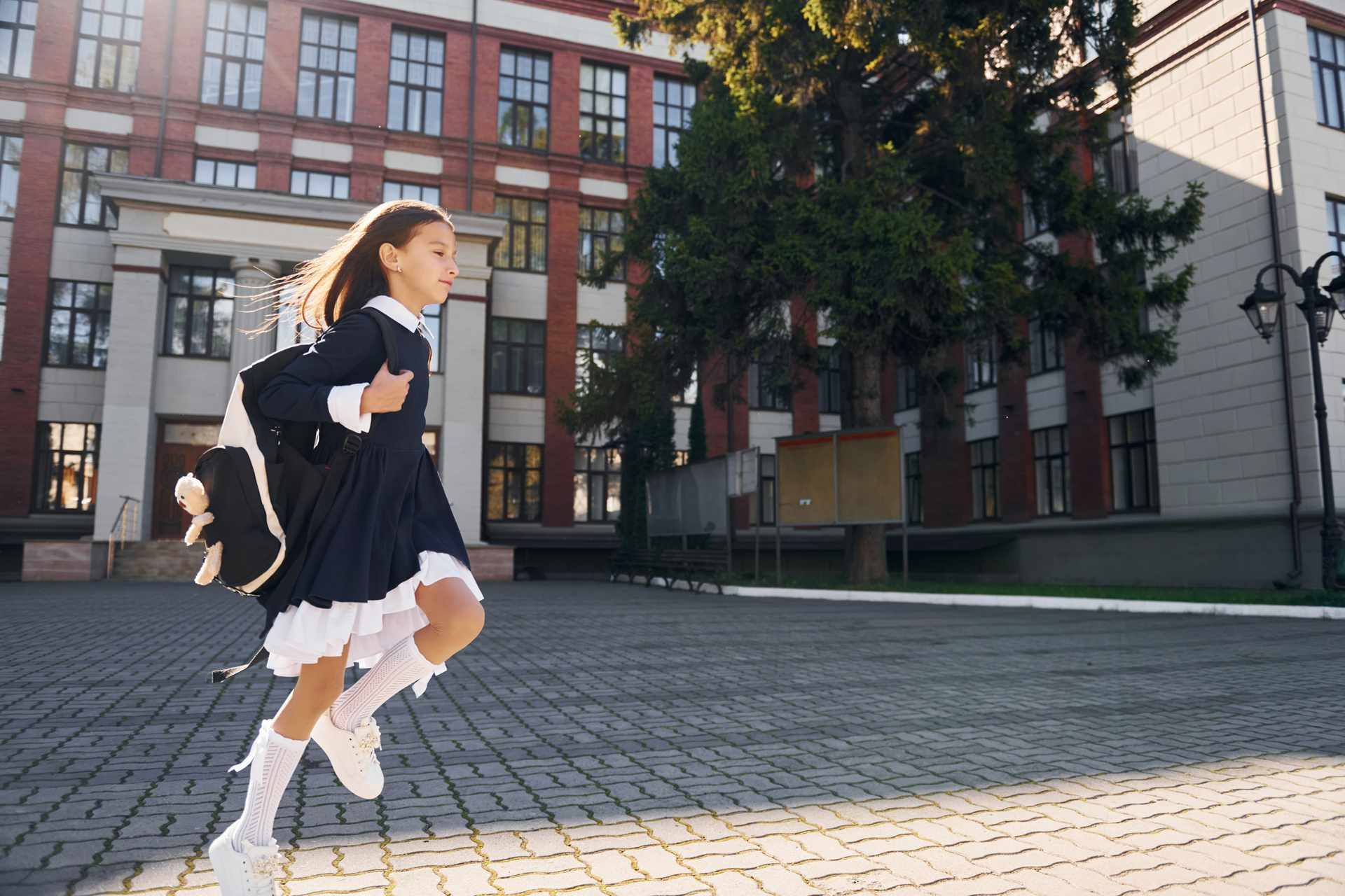 Uczennica idzie samotnie obok szkoły, planując powtórkę matury w kolejnym roku
